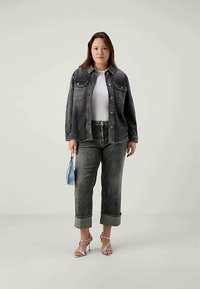 Tamsiai mėlynas džinsinis švarkas su dviem krūtinės kišenėmis, derinamas su šviesiai pilkomis džinsinėmis kelnėmis, su sukniutu rankogaliu. Papuoštas mažu mėlynu rankiniu.