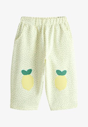 Krém színű kisgyermek nadrág zöld vonal mintával és citrom applikációval minden térden, rugalmas derékrésszel és oldalzsebekkel.