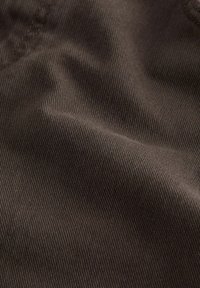 Tela marrón con una sutil textura acanalada. El material parece suave con suaves ondas y pliegues, mostrando variaciones en luz y sombra.