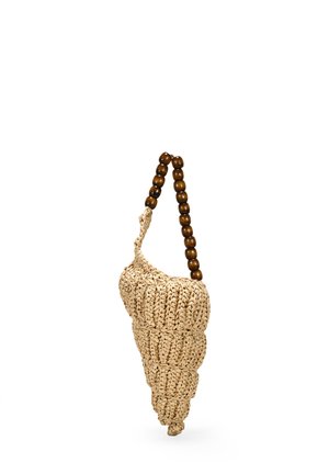 Bolso de paja tejido en forma de concha en espiral con un asa de cuentas de madera marrón. Color natural con un detalle texturizado en toda su superficie.