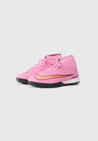 Un paio di sneaker Nike Air Zoom alte rosa con suole nere e loghi swoosh arancioni, angolati a destra su sfondo bianco.