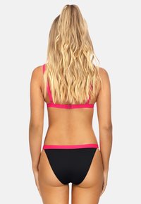 Czarny zestaw bikini z różowym wykończeniem, prezentujący halter i minimalny krój. Gładki materiał z kontrastowym akcentem kolorystycznym.