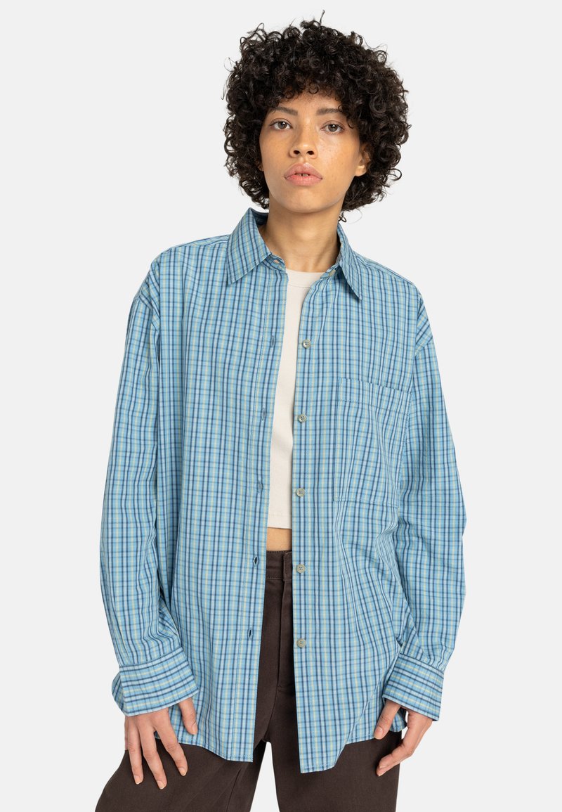 Lichtblauw geruite shirt gemaakt van zacht materiaal, met een knoopsluiting aan de voorkant, lange mouwen en een borstzak.