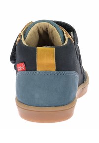 Zapato infantil de ante negro y azul con un acento marrón, cierre de velcro, cuello acolchado y suela de goma. Etiqueta de la marca roja visible.