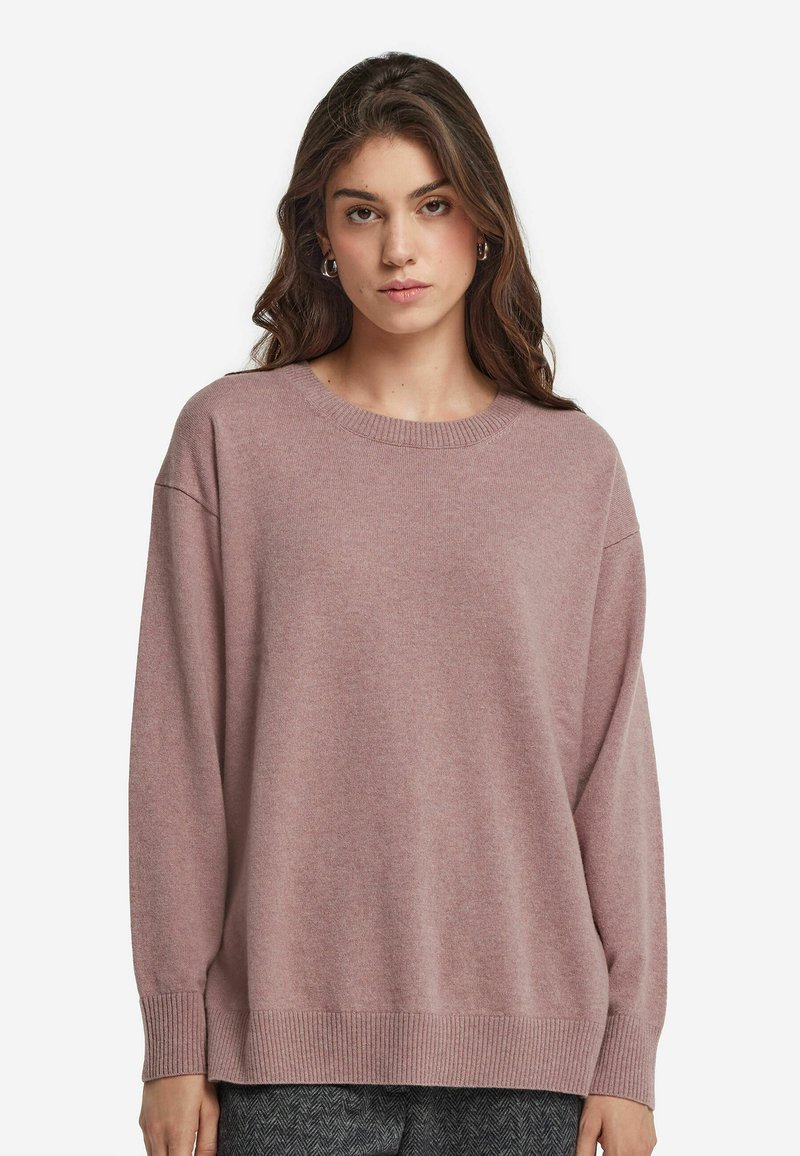 Tröja i mjuk rosa stickad tyg med rund halsringning, sänka axlar och långa ärmar. Försedd med ribbade ärmslut och nederkant.