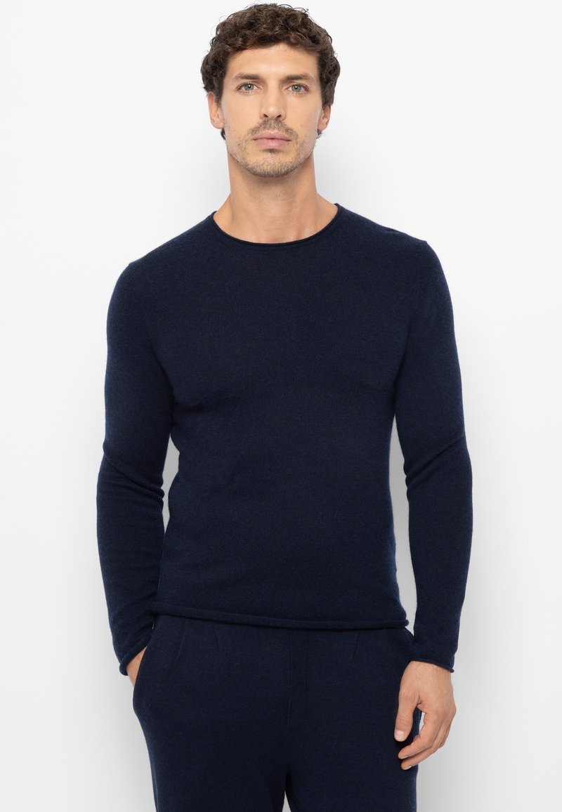 Marineblauem Pullover mit langen Ärmeln und rundem Ausschnitt, gefertigt aus einem weichen Strickmaterial. Schmale Passform mit einer glatten Textur.