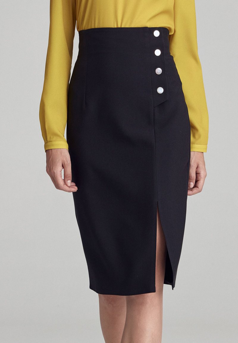 Czarna ołówkowa spódnica z wysokim stanem, z rozporkiem do uda i pięcioma metalowymi guzikami po boku. Gładka tekstura tkaniny.