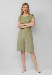 Lichtgroen geribbelde top met korte mouwen, gecombineerd met lichtgroene kniebond shorts, met een knoopsluiting aan de voorkant, zijzakken en strakke lijnen.