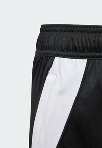 Melni sporta šorti ar teksturētu audumu, elastīgu jostu un balto svītru pa sānu kontrastam.