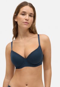 Sostenedor azul marino hecho de una tela suave, con copas acolchadas, tirantes ajustables y un delicado encaje en los bordes.