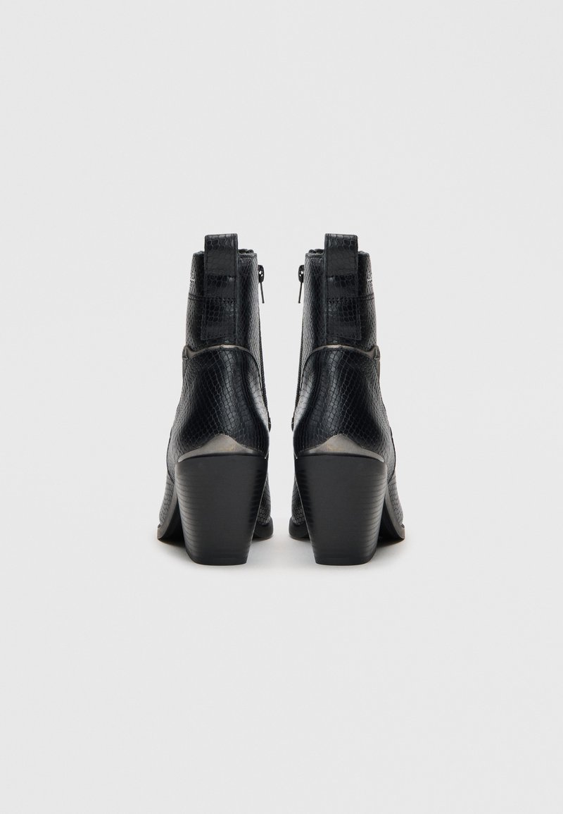Czarne botki na obcasie o długości kostki z teksturowanej skóry w wężowy wzór, z zapięciem na zamek błyskawiczny oraz zwężającym się obcasem, zapewniającym stabilność i komfort.