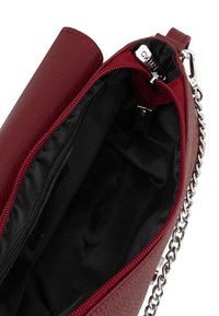 Borsa a tracolla in pelle rossa con texture, interna nera, dotata di chiusura zip e manico a catena in argento per il trasporto.