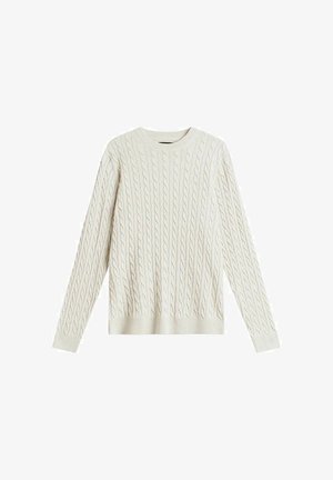 Krämfärgad kabelstickad tröja med långa ärmar, rund halsringning och ett texturerat mönster över hela plagget. Slät yta och figurnära silhuett.