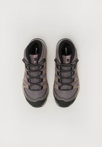 Chaussures de randonnée grises et taupe avec tiges en maille, semelles en caoutchouc noir et lacets élastiques. Présente le logo sur la languette et des semelles intérieures rembourrées.