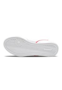 Fehér sneaker texturált gumitalppal, sima felsőrésszel és piros varrásokkal az oldalán. Kerek logó részlet található.
