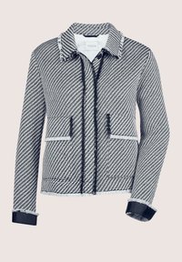 Gevoerd jasje met een houndstoothpatroon in zwart en wit. Voorzien van een kraag, twee voorkezen en marineblauwe accenten.