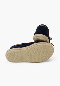 Navyblaue Wildlederschuhe mit geflochtenen Schnürsenkeln, beigen gewobenen Zwischensohlen und strukturierten Gummisohlen mit Wellenmuster.