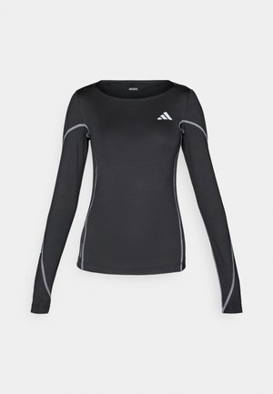 Must have pikkade varrukatega must sportlik särk ümmarguse kaelusega ja peegeldava hõbedase õmblusega. Särgi vasakus ülanurgas on väike valge logo.