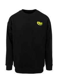 Schwarzes Sweatshirt mit langen Ärmeln, gerippten Manschetten und Saum. Auf der Brust befindet sich ein kleines gelbes Grafikdesign einer Scheibe. Stoff aus Baumwollmischung.
