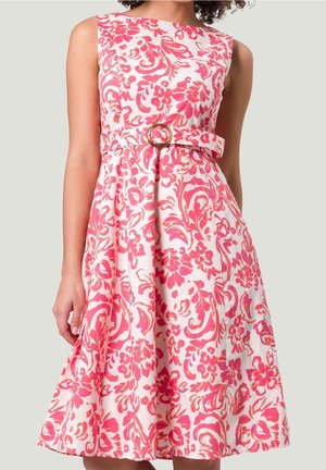 Robe fleurie en tissu rose et blanc, sans manches, avec une taille cintrée et une ceinture dotée d'une boucle circulaire. Jupe évasée avec des plis.