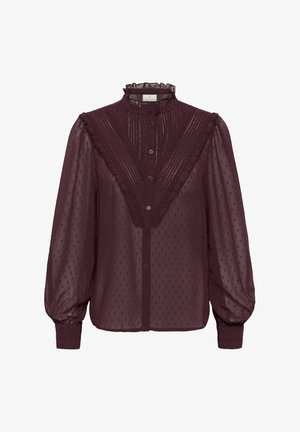 Burgundy blouse in sheer fabric, featuring a ruffled collar, button closure, and textured polka dot pattern with puffed sleeves.