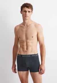 Černé bavlněné boxerky s obepínajícím střihem a elastickým pasem, na kterém je bíle uvedeno jméno značky "Marc O'Polo".