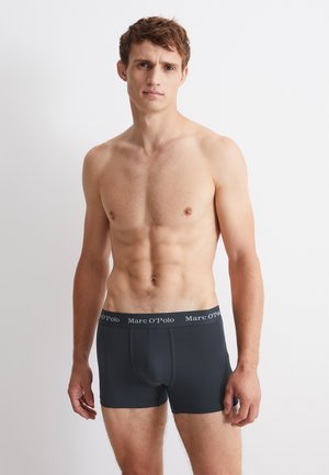 Slip in cotone nero con design aderente e vita elastica che presenta il nome del marchio "Marc O'Polo" in testo bianco.
