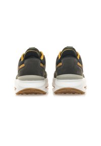 Zapatillas deportivas con parte superior de ante gris y negro, detalles en amarillo, una entresuela blanca y una suela de goma marrón texturizada.