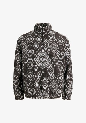 Pulover od flisa s visokim kragnom, s crno-bijelim dijamantnim uzorkom i mekom, teksturiranom površinom. Prednji zatvarač na vratu.