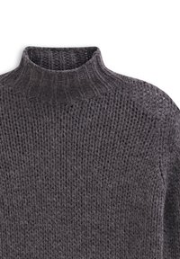 Dark gray knitted turtleneck sweater with thick ribbed collar and textured stitch pattern on torso and shoulders.