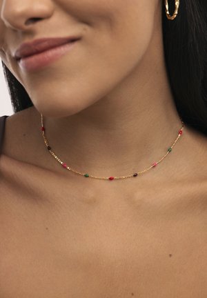Collar de cadena de oro con pequeñas cuentas coloridas en rojo, verde y púrpura. Presenta un diseño delicado con una superficie suave y brillante.