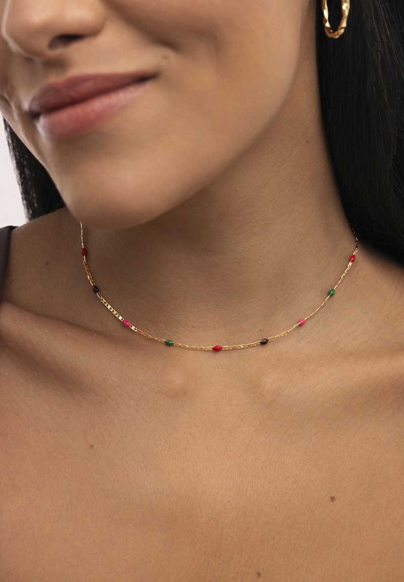 Collar de cadena de oro con pequeñas cuentas coloridas en rojo, verde y púrpura. Presenta un diseño delicado con una superficie suave y brillante.
