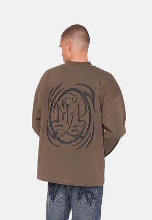 Oversized brown sweatshirt featuring a large black graphic design on the back, with long sleeves and a crew neckline.