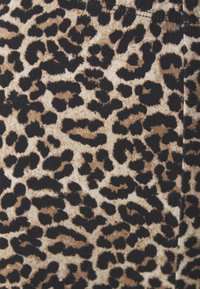 Tessuto con stampa leopardata caratterizzato da un motivo marrone chiaro e nero. Morbida consistenza, con forme e dimensioni variabili delle macchie su uno sfondo beige.