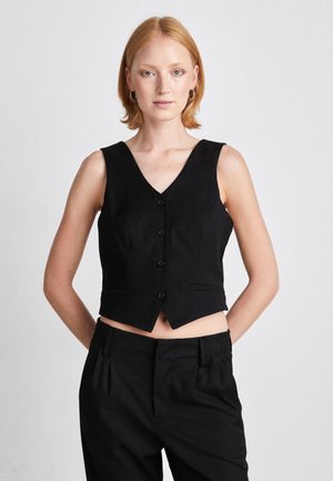 Gilet nero con scollatura a V, cinque bottoni e due tasche frontali. Il tessuto appare liscio con una vestibilità tailored e cropped.