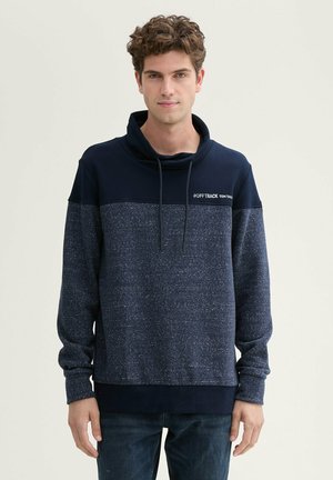 Felpa pullover blu navy con collo alto, caratterizzata da un design testurizzato e un motivo a righe orizzontali più chiare. Include lacci e logo.
