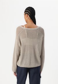 Beige gestrickter Pullover mit offener Maschenstruktur, weitem Ausschnitt und Raglanärmeln. Verfügt über eine strukturierte Oberfläche und eine lockere Passform. Rückansicht gezeigt.