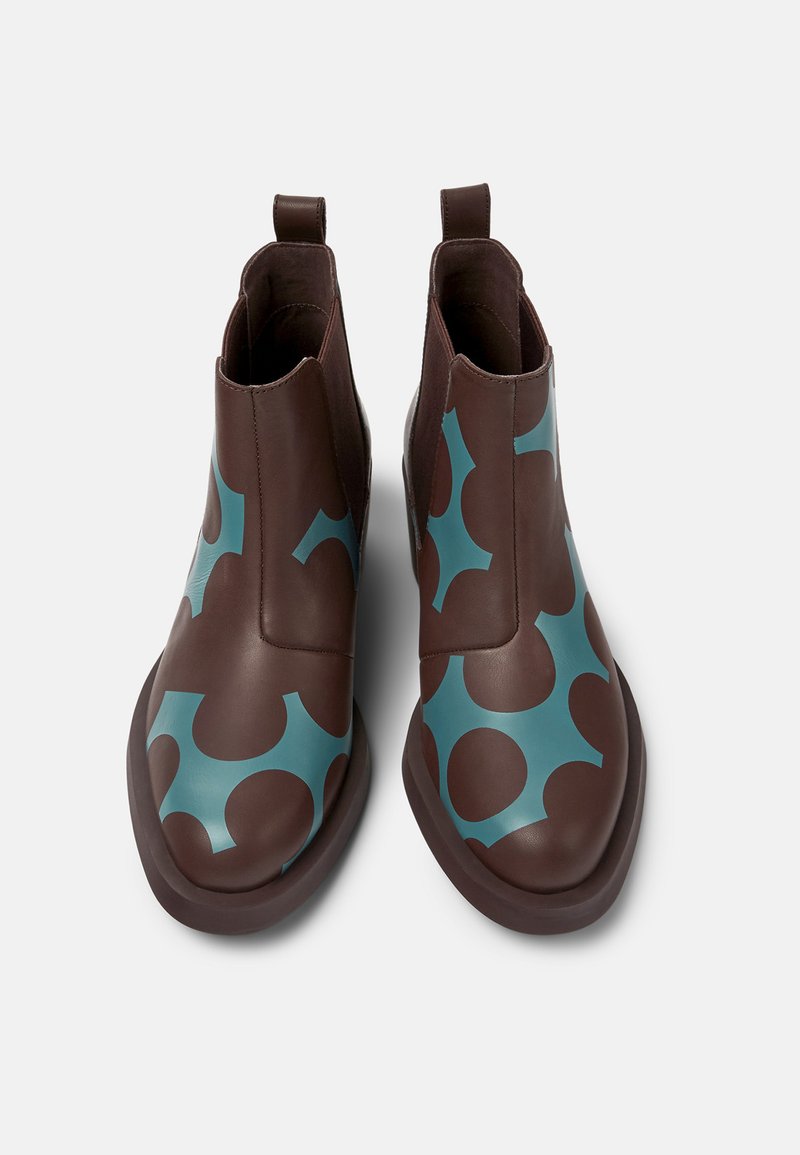 Braune Lederstiefeletten mit einem türkisfarbenen abstrakten Muster. Glatte Textur mit runder Zehenpartie und Ziehlaschen für ein einfaches Anziehen.