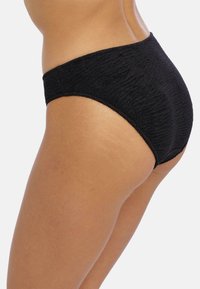 Svart stickad bikiniunderdel med en texturerad mönster, hög midja design och en slät yta, sedd från sidan.
