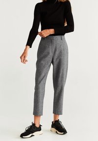 Grijze op maat gemaakte broek met een gestructureerde afwerking, voorzien van een hoge taille, zijzakken en een cropped ontwerp, gecombineerd met zwarte sneakers.