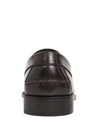 Zwarte leren schoenen met een gepolijste afwerking, ronde neus en een lage hak, met zichtbare stiksels langs de zijkanten.