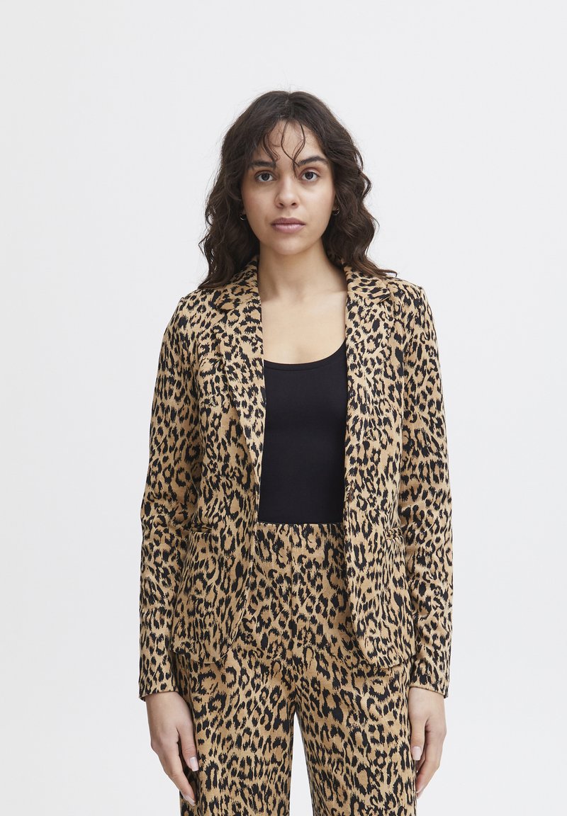 Blazer in stampa leopardata realizzato in tessuto leggero, con chiusura a un bottone, bavero a punte e due tasche frontali. Abbinato a pantaloni coordinati.