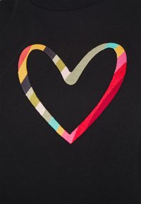 Forme de cœur rayée colorée brodée sur fond de tissu noir.
