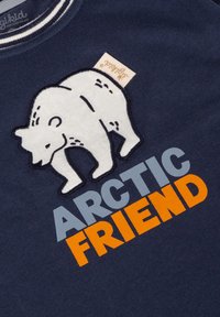 Navyblauer Pullover mit einem weißen gestickten Design eines Eisbären. Der Text lautet "ARCTIC FRIEND" in Orange und Hellblau. Gerippter Halsausschnitt.