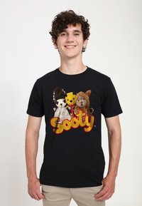Svart t-shirt med mjukisdjur, inklusive en panda, en gul björn och ett lejon. Fet "Sooty" logotyp i gult under.