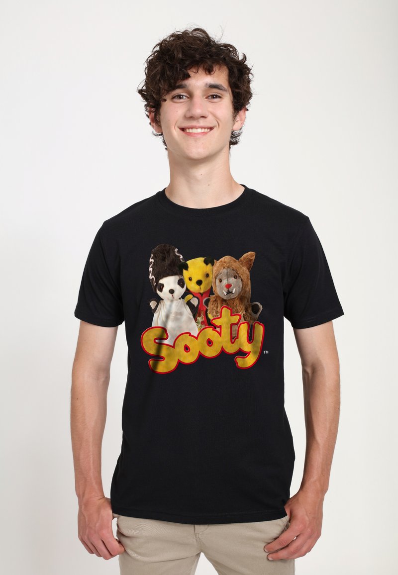 Svart t-shirt med mjukisdjur, inklusive en panda, en gul björn och ett lejon. Fet "Sooty" logotyp i gult under.