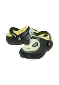 Zoccoli neri con design a faccia di alieno, rivestimento giallo in pelliccia morbida e fascia posteriore regolabile. Realizzati in materiale leggero con suola texturizzata.