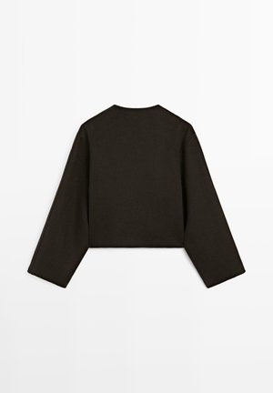 Cropped, long-sleeve top made of dark fabric. Features a round neckline and a clean silhouette with minimal stitching at edges.