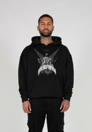 Black hoodie with a front graphic featuring wings and a figure. Material appears soft. Simple design with a drawstring hood and kangaroo pocket.