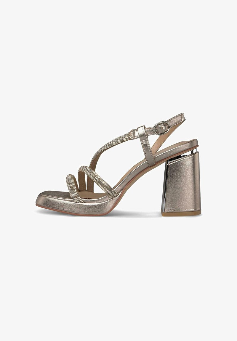 Metallisch goldene Riemchensandale mit hohen Absätzen und Blockabsatz, verstellbarem Knöchelverschluss und glitzernden, strukturierten Riemen über dem Fuß.